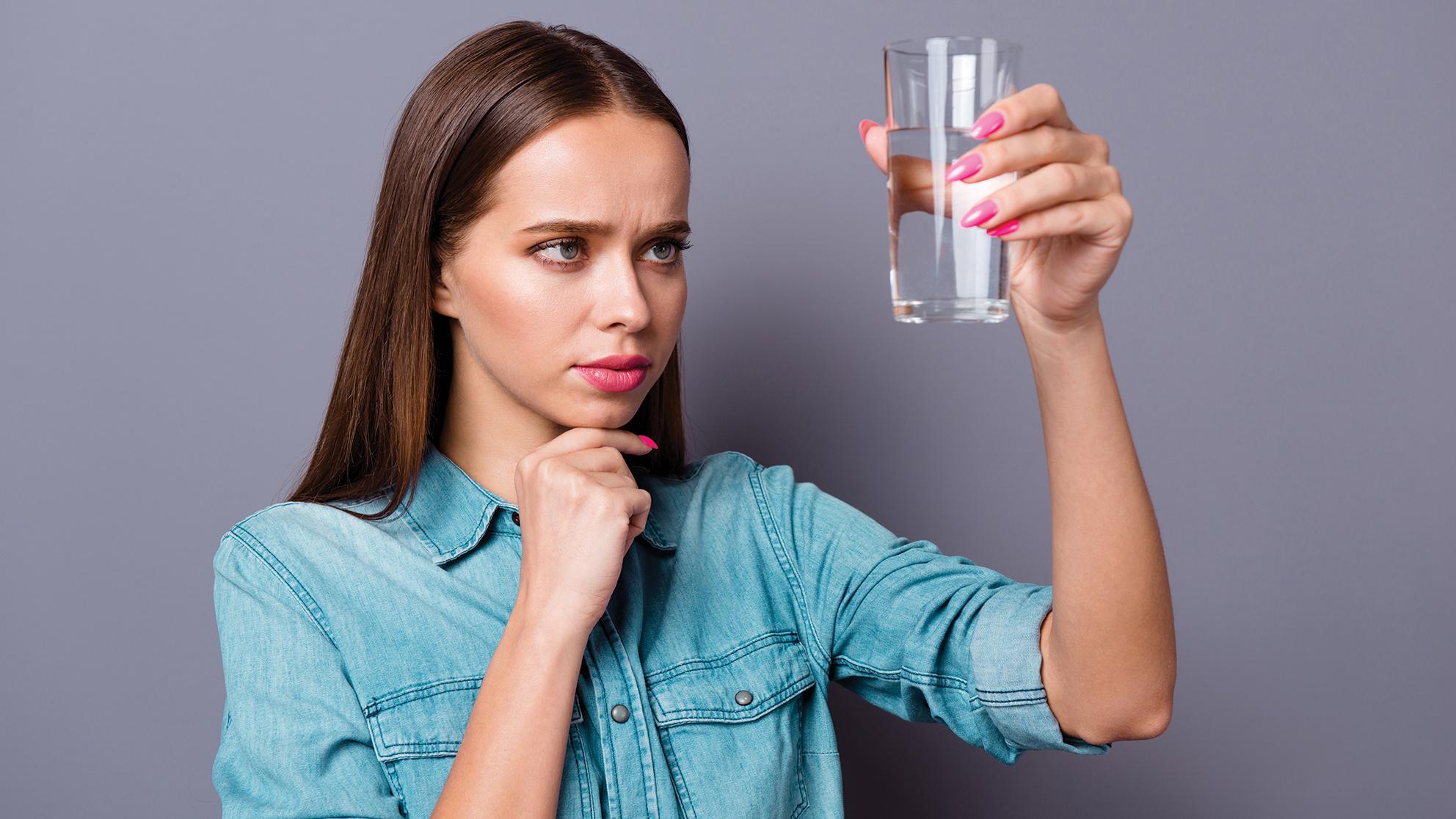 Woman looking at class of water